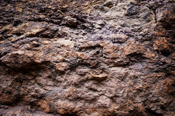 Brown rough stone wall for abstract background and texture for interior or exterior design. Beautiful patterns, space for work, banner, wallpaper close up.