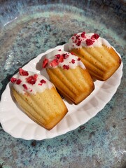 Freshly Baked Golden Madeleines With White Chocolate And Rasberrys