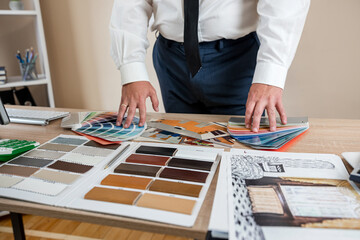 Male engineer working with color palette and drawing sketch house plan at office