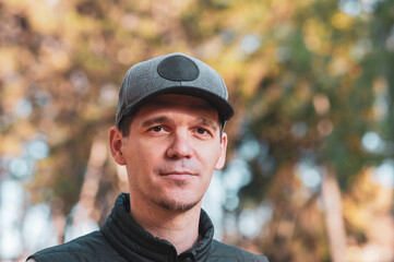 A close-up portrait of a man in a park 
