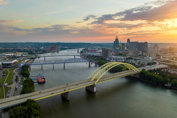 Fototapeta premium Aerial view of downtown district highway traffic in Cincinnati city, Ohio at sunset. Brightly illuminated high skyscraper buildings in modern American midtown