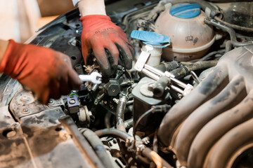 Obraz premium Mechanic Working on Car Engine with Tools