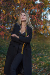 Blonde hair lady in black wool coat and golden scarf, fashionable trends for women, real photo outdoor portrait