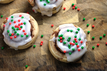 Homemade cinnamon rolls with frosting from top view with Christmas holiday sprinkles.