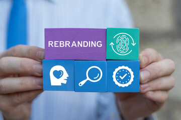 Man holding styrofoam blocks sees word: REBRANDING. Rebrand, Marketing, Management Concept. Brand Change. Rebranding Strategies for Business Transformation. Rebuilding marketing strategy and design.