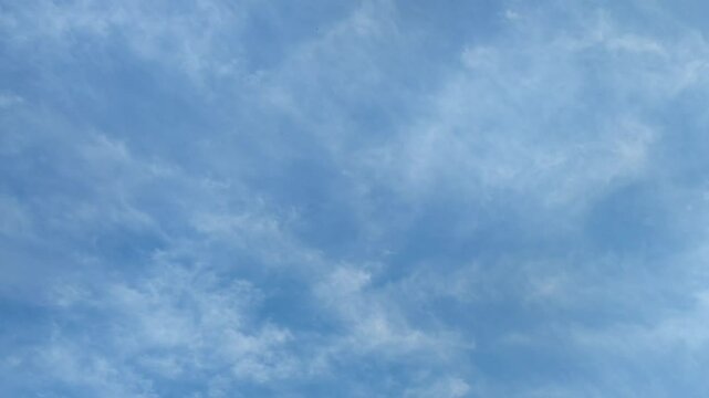 Clouds are floating in sky. Blue sky with white cirrus clouds that are moving sedately across the sky. They are located at different heights and almost do not change their shape and size as they move.