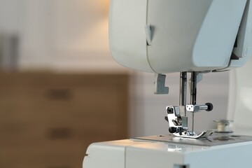 Sewing machine on blurred background, macro view. Space for text