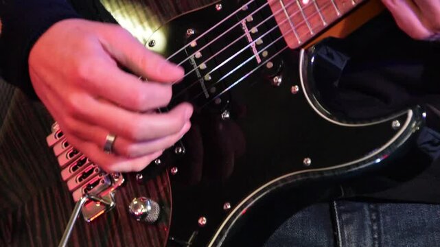 Close-up of Acoustic Guitar Playing with a Male Hand Strumming in a Studio Setting