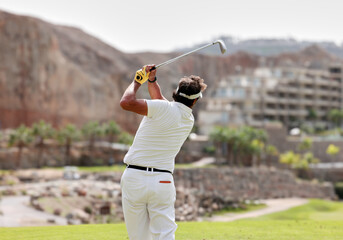 The golfer hits the golf ball with the Drive in his hand, on the tee.