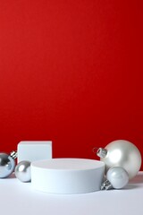 White podiums with Christmas decorations on color background 