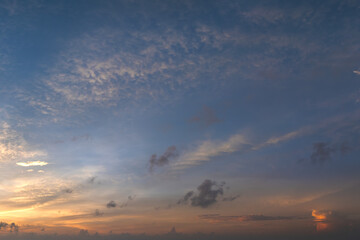 Colorful sunset sky with setting sun behind vivid orange and yellow clouds