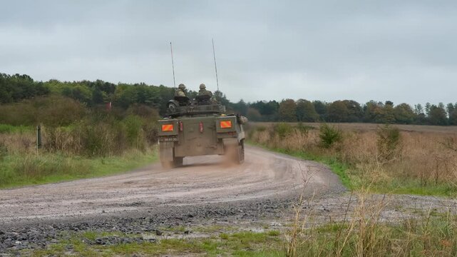 British army Warrior FV510 IFV moving along a wet dirt track