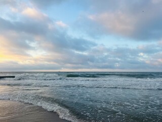 Tender purple clouds reflection at the seashore, beautiful sunset seascape, empty sea beach, fantastic clouds reflection on the sea surface