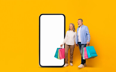 A cheerful older couple stands side by side, holding shopping bags in vibrant colors. They are positioned next to a large blank smartphone screen, set against a lively yellow backdrop.