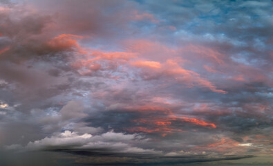 Dramatic sunset sky covered with colorful yellow clouds. Panoramic skyscape