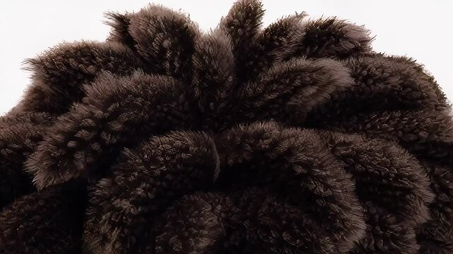 Close-up of brown fluffy texture against dark background, resembling softness and luxury, ideal for winter, fashion, or elegance-themed visuals with a sense of warmth and sophistication