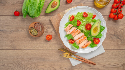 Plate of healthy food chicken fillet, avocado and salad on a wooden background. top view. copy space