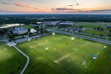 Public sports stadium with young people playing football game at sunset. Active way of life concept © bilanol