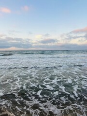 Tender purple clouds reflection at the seashore, beautiful sunset seascape, empty sea beach, fantastic clouds reflection on the sea surface