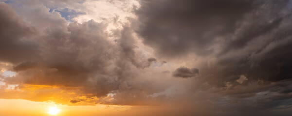 Obraz premium Stormy cumulonimbus clouds before thunderstorm on dark sunset sky. Moving and changing cloudscape weather
