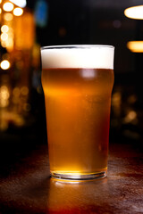 pint of pale ale craft beer on blurred pub bar background