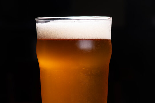 pint of pale ale craft beer in macro close-up on foam and dark background