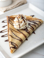 Chocolate-drizzled crepe with whipped cream topping on plate