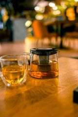 A cup and a teapot on a table in a restaurant. The concept of tea