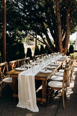Minimalist wedding table decor: white textiles, glass vases and candles.