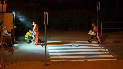 Nighttime Roadwork in the City: Workers and Machinery Repairing Urban Roads Under Artificial Light