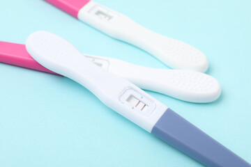 Pregnancy tests on light blue background, closeup
