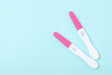 Pregnancy tests on light blue background, top view