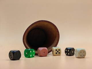 Shake and Roll the Dice – Leather Dice Cup with Colorful Dice on Light Brown Background