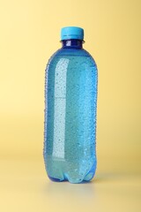 Plastic bottle of water on yellow background