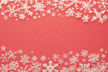 White snowflakes on a red background, creating an atmosphere of Christmas and winter holidays, copy space 