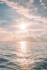 Obraz premium The sun's warm hues dance on the ocean's surface as it glistens at sunset