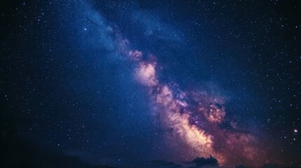 Fototapeta premium A stunning view of the Milky Way galaxy stretching across the night sky, filled with twinkling stars and vibrant colors.