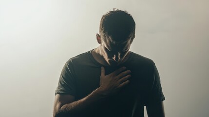 Man clutching his chest, experiencing a heart attack, stands alone against a white backdrop.