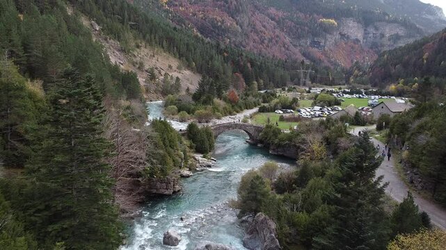 Vista a&eacute;rea de un r&iacute;o en el Parque Nacional de Ordesa con puente de piedra y excursionistas