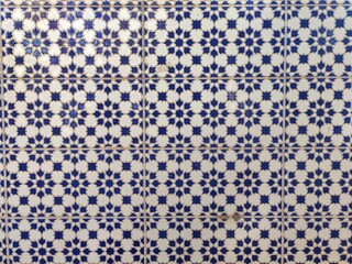 Traditional Spanish ceramic tile pattern in blue and white, featuring intricate geometric shapes and star designs