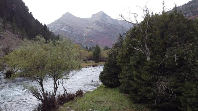Vuelo de dron sobre un r&iacute;o con paisaje monta&ntilde;oso y excursionistas en el Parque Nacional de Ordesa