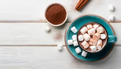 Overhead view of hot chocolate in a blue green mug with whipped cream and mini marshmallows on white wooden background 