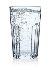 Pouring soda water from bottle into glass on white background