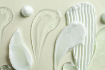 Smears of different cosmetic products on white background, flat lay