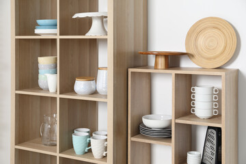 Wooden shelving units with kitchenware on white background