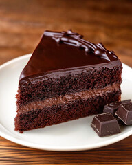 Slice of rich chocolate cake topped with ganache