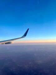 airplane wing over sunset in the city