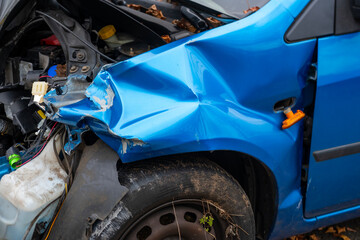 heavily damaged car with crumpled hood and exposed engine, aftermath collision, crash scene, with...