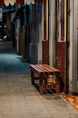 Banco de jardín vacío, en una vereda de noche, fuera de una cafetería, en una de las calles de la ciudad de Yurimaguas, Loreto - Perú.