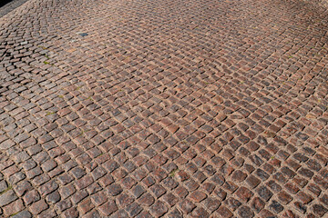 Fototapeta premium Stone road pattern background. Cobblestone pavement background. Textured background of cobblestone road. Brick road background.